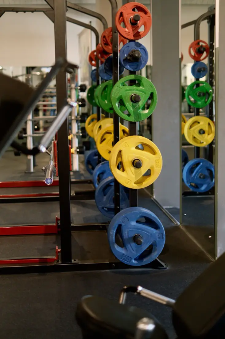 Weight plates racked on a rail in a gym